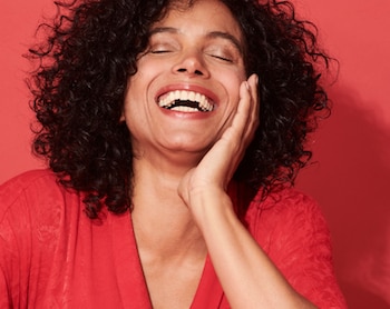 wanita tersenyum di dalam bilik merah