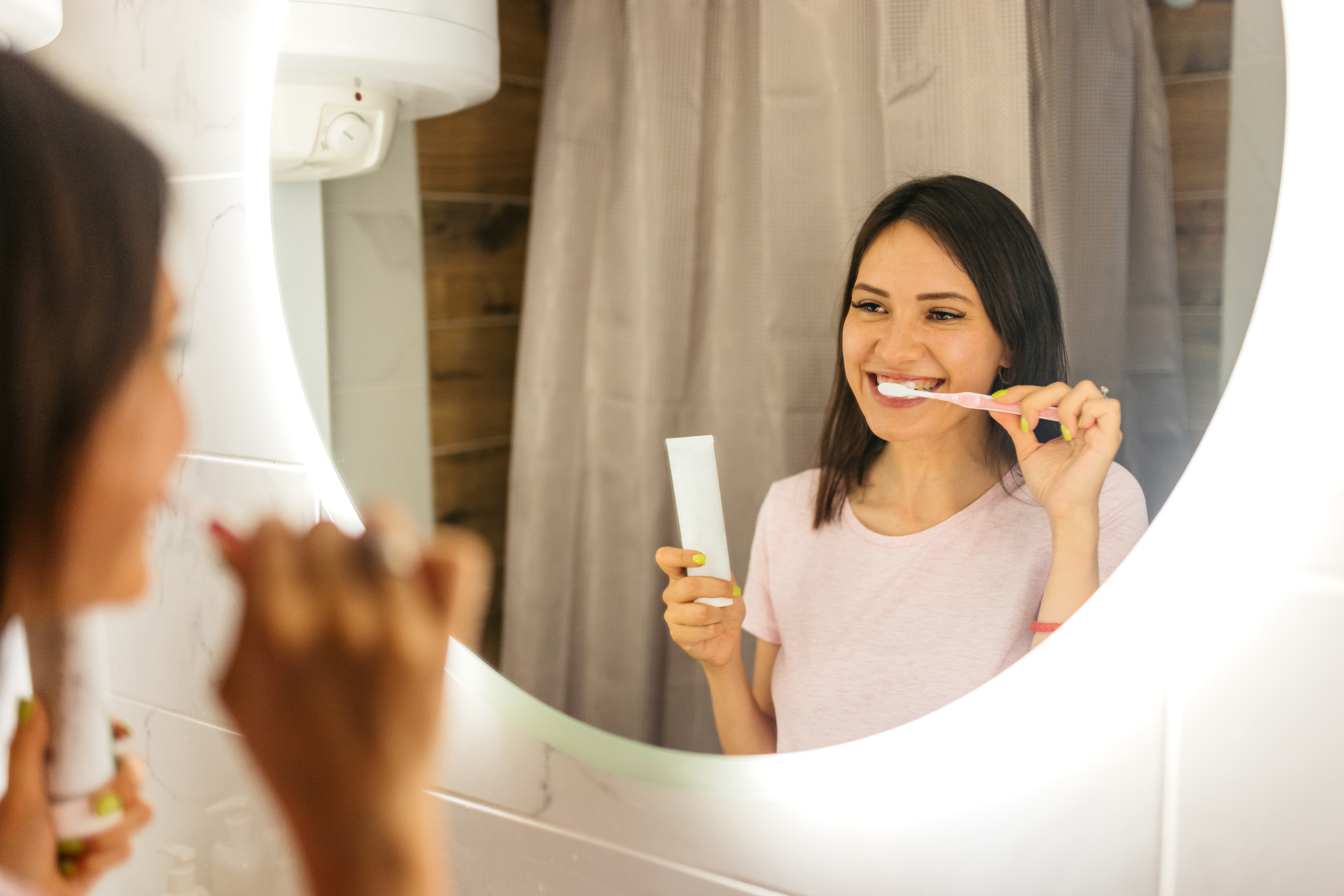 Woman treating her bleeding gums by brushing her teeth