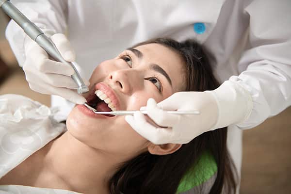 Woman smiling after teeth whitening, cost discussed  